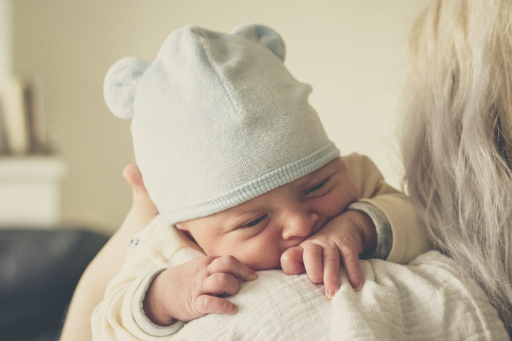 Postpartum doula holding newborn baby